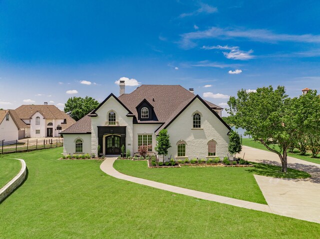 french provincial home with a front lawn