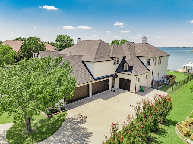 french provincial home with stucco siding, a chimney, fence, and a front yard