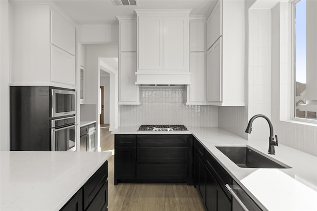 kitchen featuring sink, white cabinets, stainless steel appliances, and light hardwood / wood-style floors