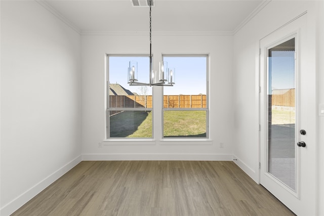 unfurnished dining area with crown molding, a notable chandelier, and hardwood / wood-style flooring