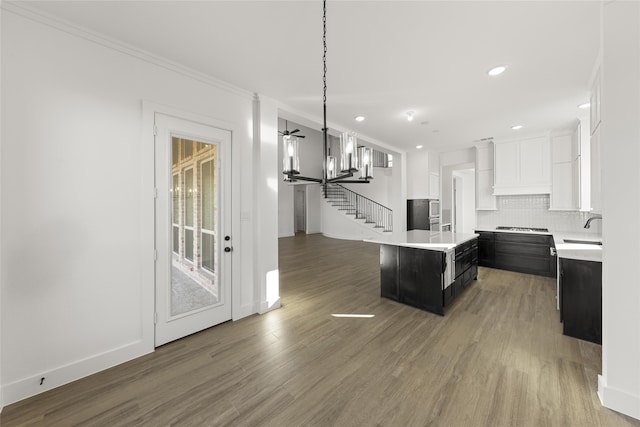 kitchen with dark hardwood / wood-style flooring, a center island, white cabinets, and sink