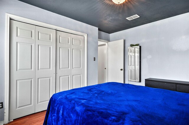 bedroom featuring dark wood-type flooring and a closet