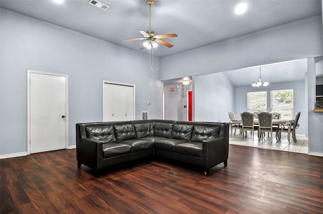 living room featuring ceiling fan with notable chandelier, high vaulted ceiling, and dark tile patterned floors