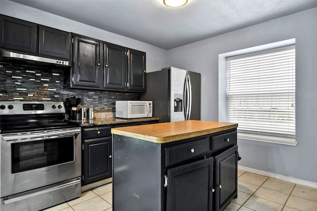 kitchen with tasteful backsplash, light tile patterned floors, a center island, and stainless steel appliances