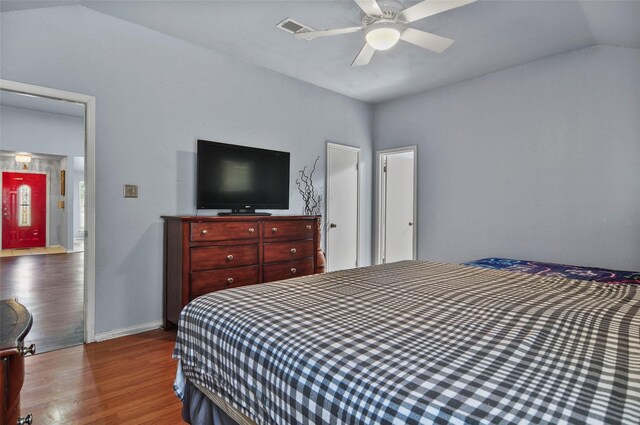 bedroom with wood-type flooring, ceiling fan, and vaulted ceiling