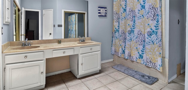 bathroom with tile patterned flooring, vanity, and walk in shower