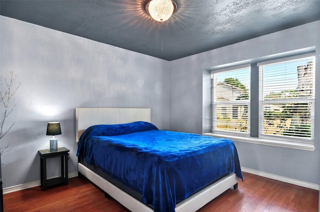 bedroom with baseboards and dark wood finished floors