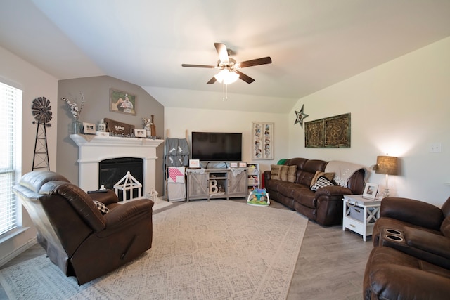 living room with light wood-type flooring, vaulted ceiling, and ceiling fan