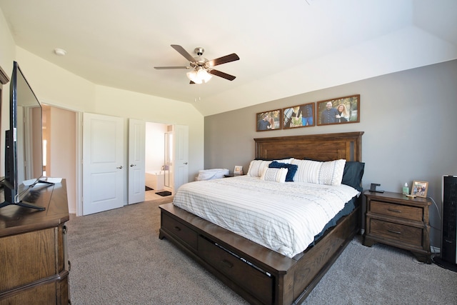 bedroom featuring carpet, ensuite bath, vaulted ceiling, and ceiling fan