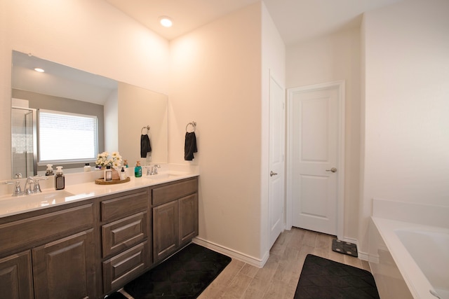 bathroom featuring vanity, wood-type flooring, and separate shower and tub