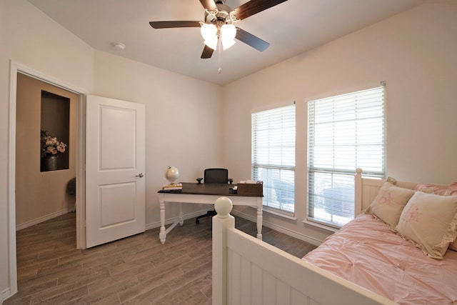 bedroom featuring ceiling fan, wood-type flooring, and multiple windows