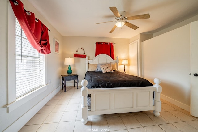 bedroom with a ceiling fan, baseboards, and light tile patterned floors