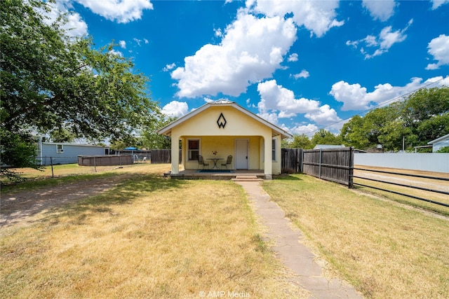 view of front of home featuring a front yard, a fenced backyard, and stucco siding