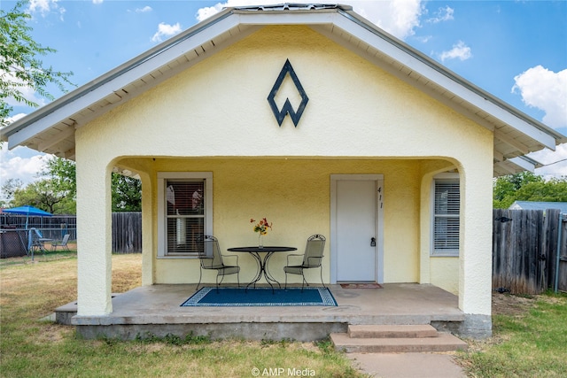 exterior space with a patio, fence, and stucco siding