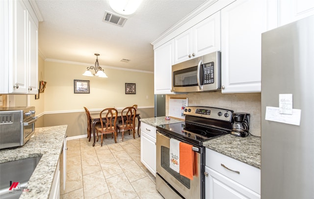 kitchen with ornamental molding, white cabinets, a notable chandelier, and stainless steel appliances