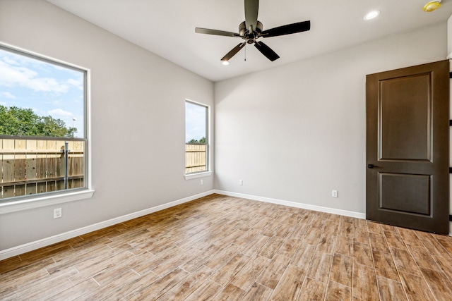 spare room featuring a ceiling fan, recessed lighting, wood finished floors, and baseboards