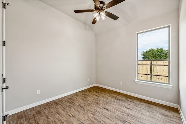 unfurnished room featuring lofted ceiling, wood finished floors, baseboards, and ceiling fan