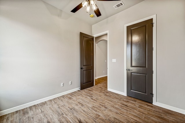 unfurnished bedroom with ceiling fan, wood finished floors, visible vents, and baseboards