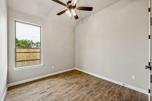 spare room with baseboards, lofted ceiling, a ceiling fan, and wood finished floors