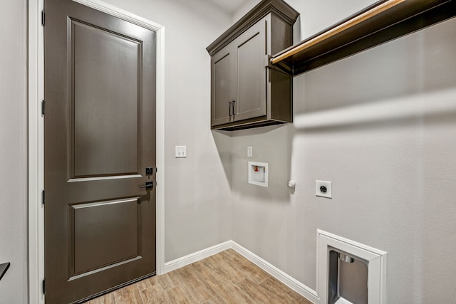 clothes washing area with baseboards, light wood-type flooring, washer hookup, cabinet space, and electric dryer hookup