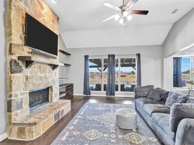 living room featuring vaulted ceiling, ceiling fan, a fireplace, and dark wood-type flooring