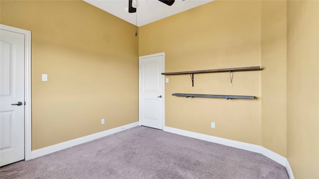 carpeted spare room featuring a high ceiling and ceiling fan