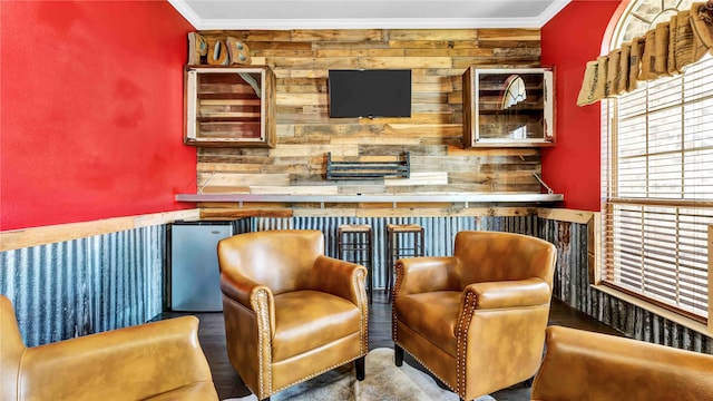 living area featuring wood-type flooring and crown molding