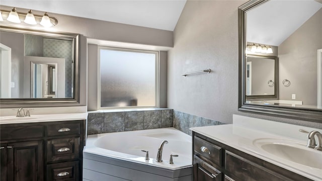 bathroom featuring vaulted ceiling, vanity, and a bathing tub