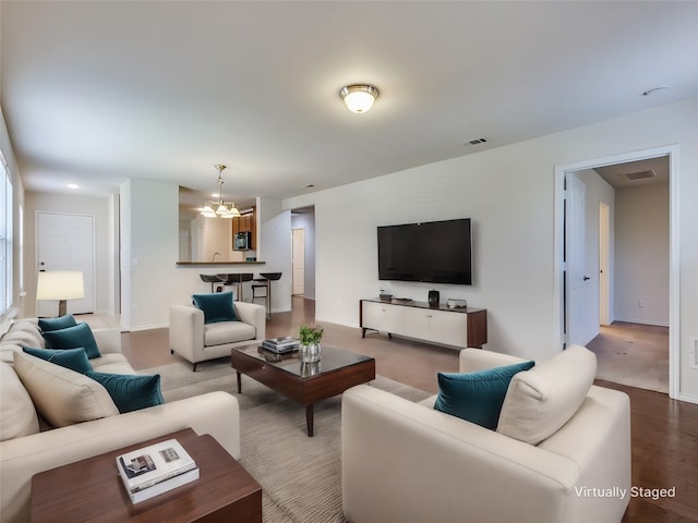 living area featuring a chandelier, visible vents, and baseboards