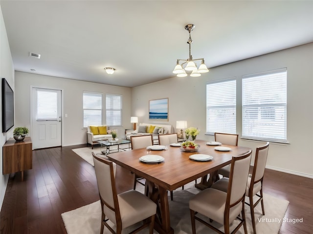 dining room featuring baseboards, dark wood finished floors, visible vents, and an inviting chandelier