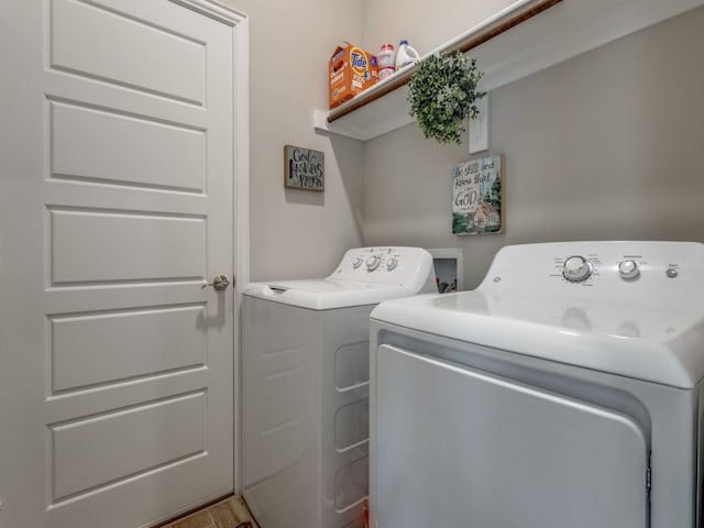 washroom with washing machine and dryer and light hardwood / wood-style flooring