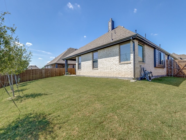 rear view of house featuring a lawn