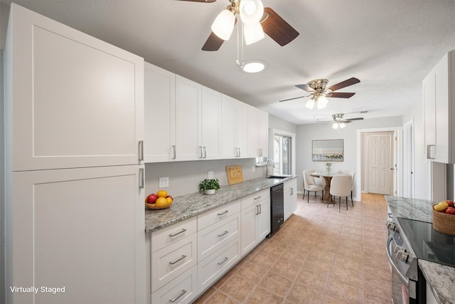 kitchen featuring ceiling fan, stainless steel range with electric cooktop, black dishwasher, light stone counters, and white cabinets