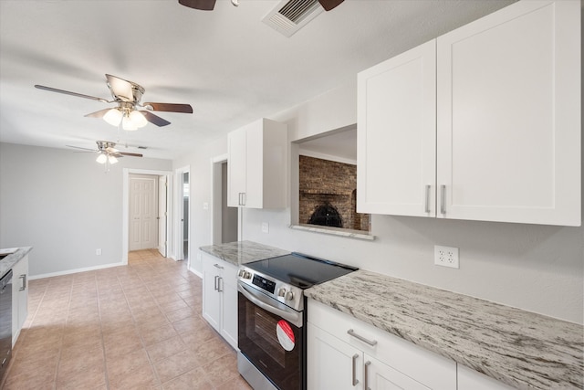 kitchen with light stone countertops, electric stove, light tile patterned floors, and white cabinets