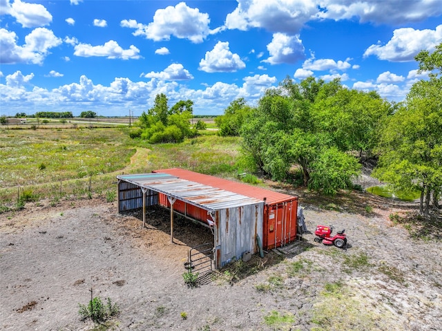 view of yard with a rural view and an outbuilding