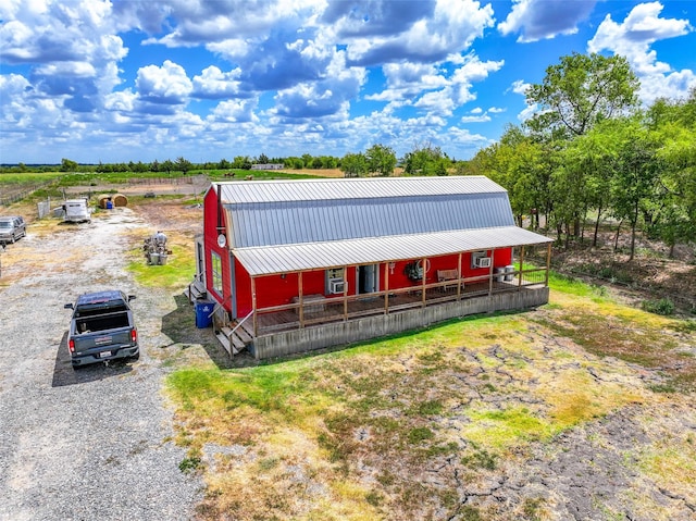 view of front of property featuring an outbuilding, metal roof, gravel driveway, and a gambrel roof