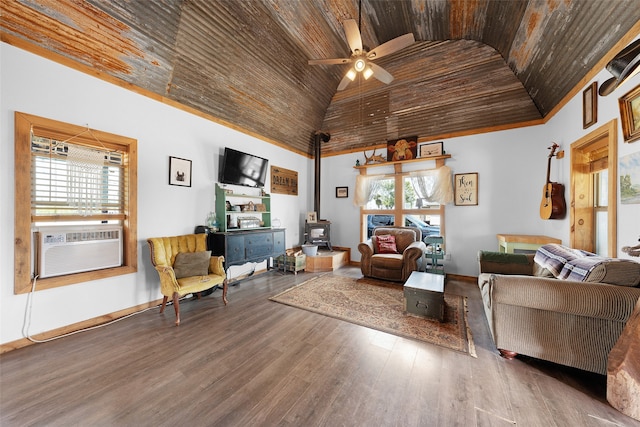 living room with plenty of natural light, a wood stove, wood-type flooring, and ceiling fan