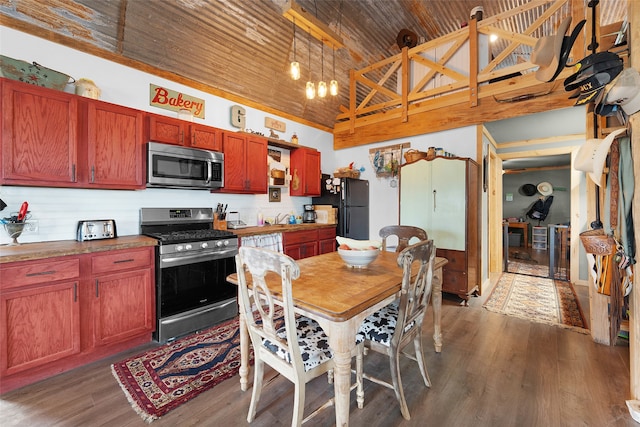 kitchen with wood ceiling, stainless steel appliances, dark hardwood / wood-style floors, and a towering ceiling