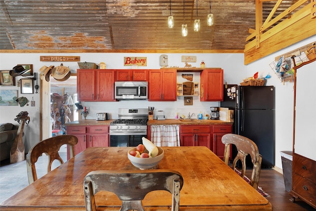 kitchen featuring stainless steel appliances, dark wood-style flooring, and decorative light fixtures