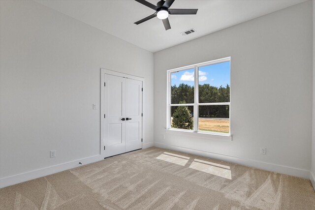 carpeted empty room featuring ceiling fan