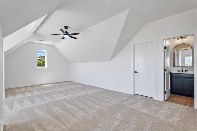 bonus room with light colored carpet, lofted ceiling, a wealth of natural light, and ceiling fan