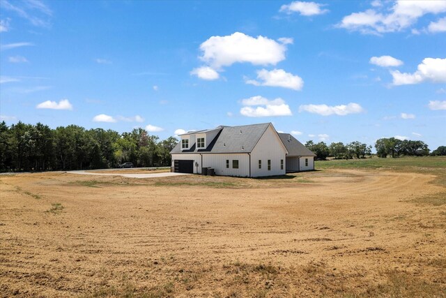 modern inspired farmhouse with a garage, central AC unit, and a porch