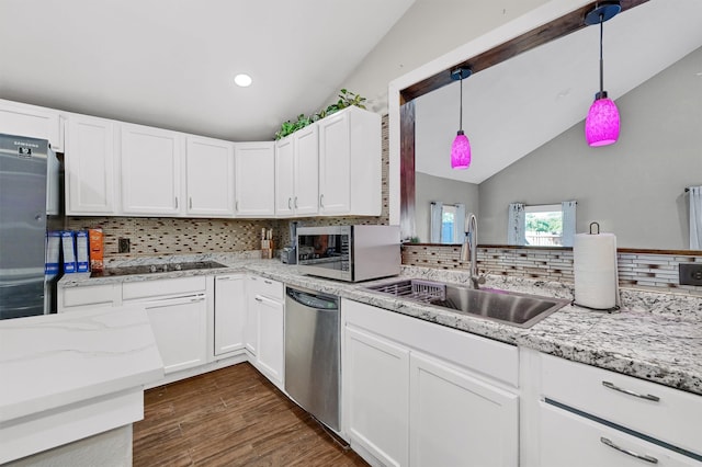 kitchen with backsplash, vaulted ceiling, sink, dark wood-type flooring, and appliances with stainless steel finishes