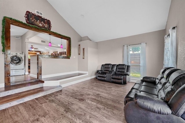 living room featuring washer / dryer, high vaulted ceiling, and hardwood / wood-style floors