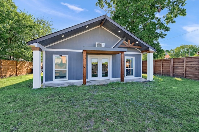 back of property with a yard and french doors