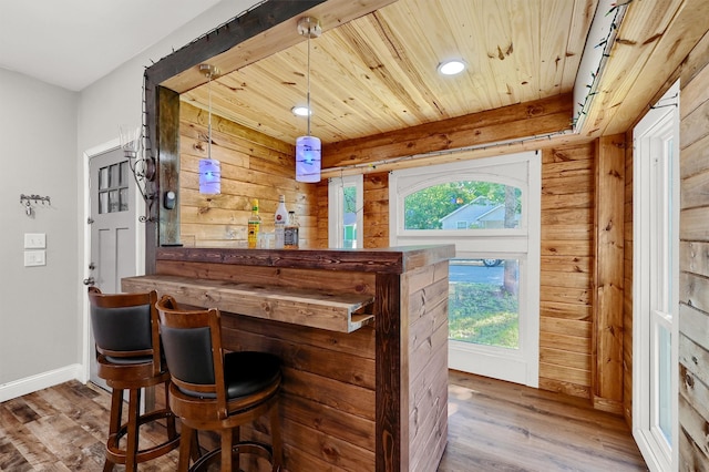 bar with decorative light fixtures, wood ceiling, dark hardwood / wood-style floors, wooden counters, and wood walls