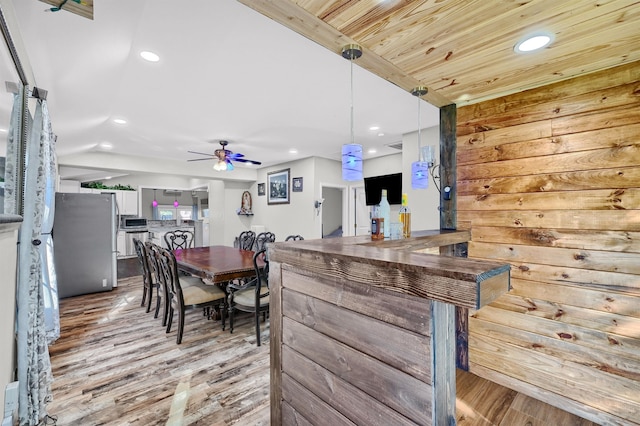 kitchen with pendant lighting, ceiling fan, stainless steel fridge, and light hardwood / wood-style floors