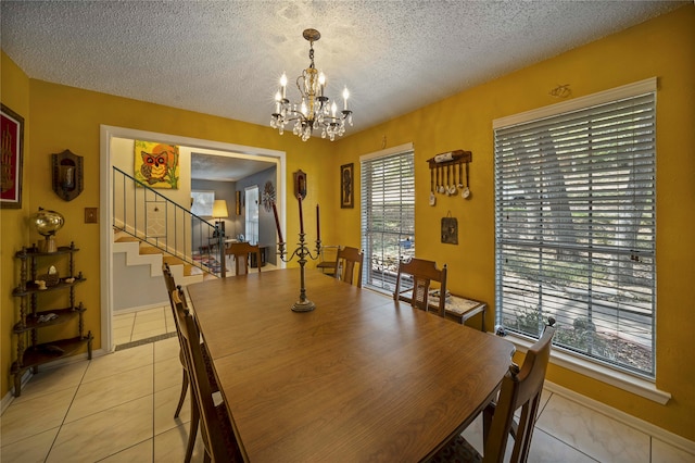 tiled dining area featuring a notable chandelier, a textured ceiling, and a wealth of natural light