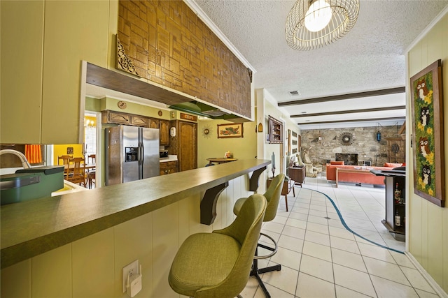 kitchen with stainless steel fridge, a textured ceiling, ornamental molding, and light tile patterned flooring