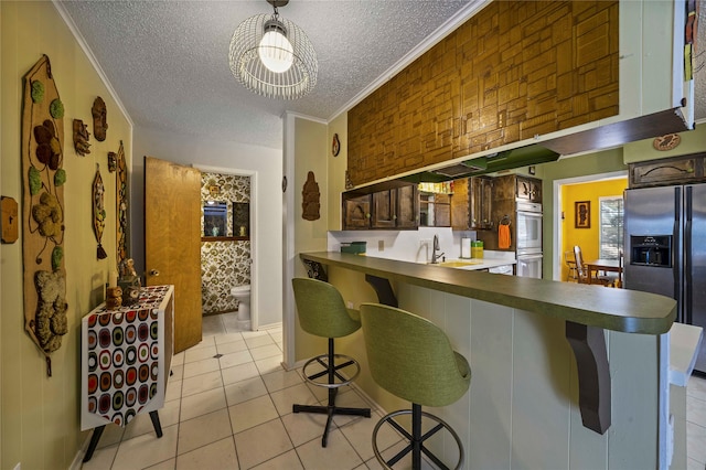 kitchen with stainless steel fridge with ice dispenser, kitchen peninsula, crown molding, a breakfast bar area, and light tile patterned flooring